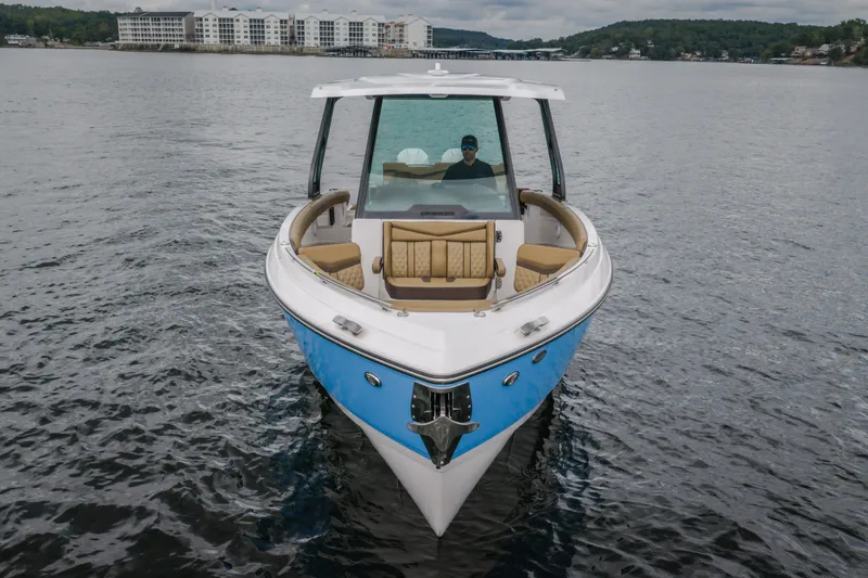 Slide: The Image of 2026 Monterey Elite 30 OB boat on calm water, front view with modern design. - 2