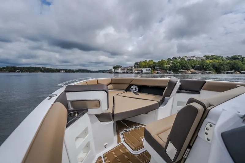 Slide: The Image of 2026 Monterey Elite 30 OB boat interior with luxurious seating on a scenic lake. - 29