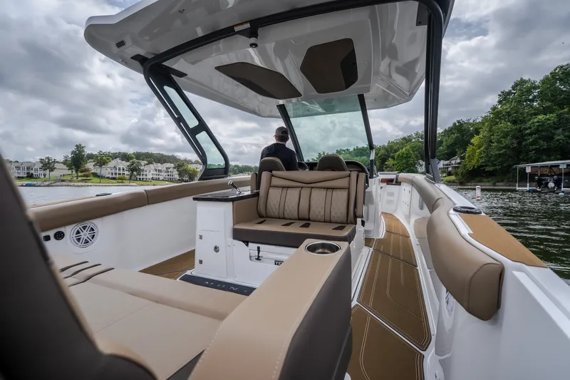 Slide: The Image of 2026 Monterey Elite 30 OB boat interior with luxurious seating on a scenic lake. - 7