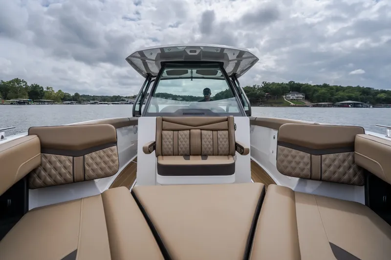 Slide: The Image of 2026 Monterey Elite 30 OB boat interior with luxurious seating on a lake. - 34