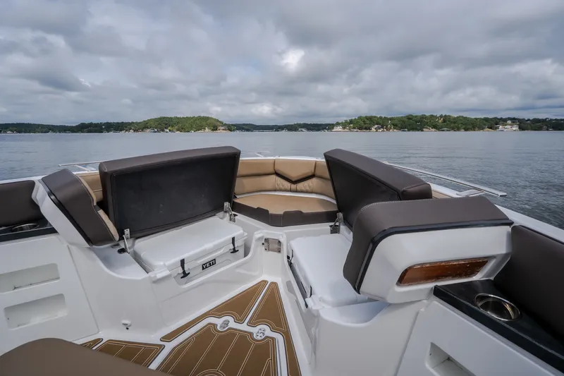 Slide: The Image of 2026 Monterey Elite 30 OB boat interior with cushioned seating and scenic lake view. - 33