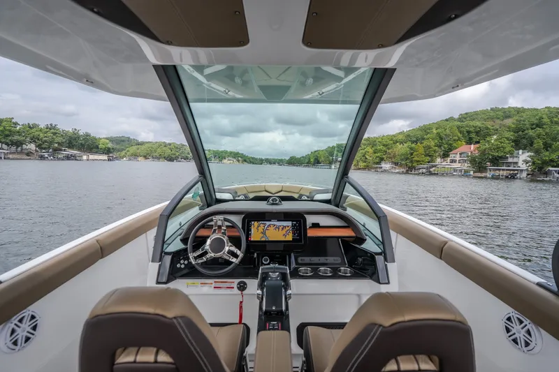 Slide: The Image of 2026 Monterey Elite 30 OB boat interior with modern dashboard on a scenic lake. - 13