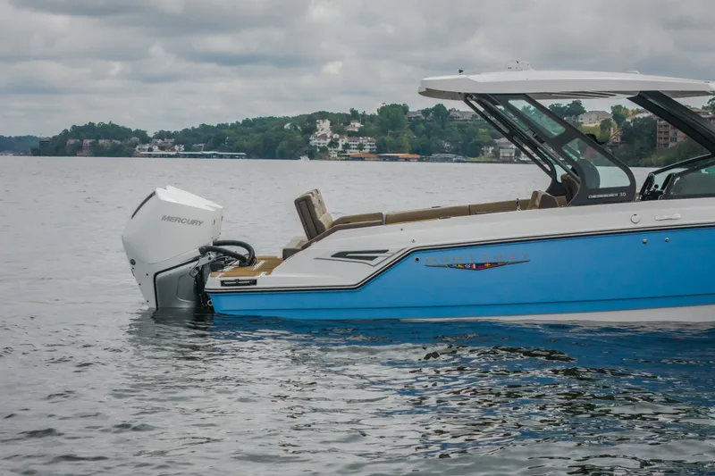 Slide: The Image of 2026 Monterey Elite 30 OB boat on calm water, featuring sleek design and Mercury outboard engine. - 56