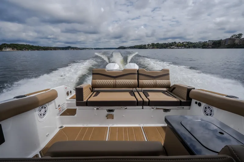 Slide: The Image of 2026 Monterey Elite 30 OB boat cruising on a scenic lake with plush seating. - 51