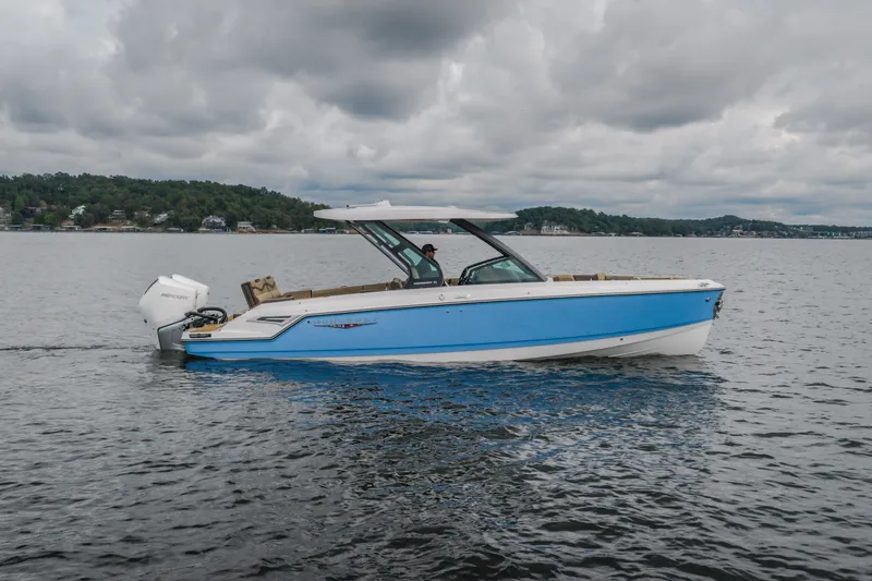 Slide: The Image of 2026 Monterey Elite 30 OB boat on a lake under cloudy skies. - 65
