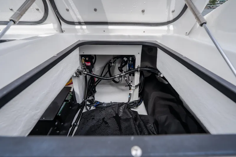 Slide: The Image of Open storage compartment of 2026 Monterey Elite 30 OB boat, showcasing internal wiring and components. - 49