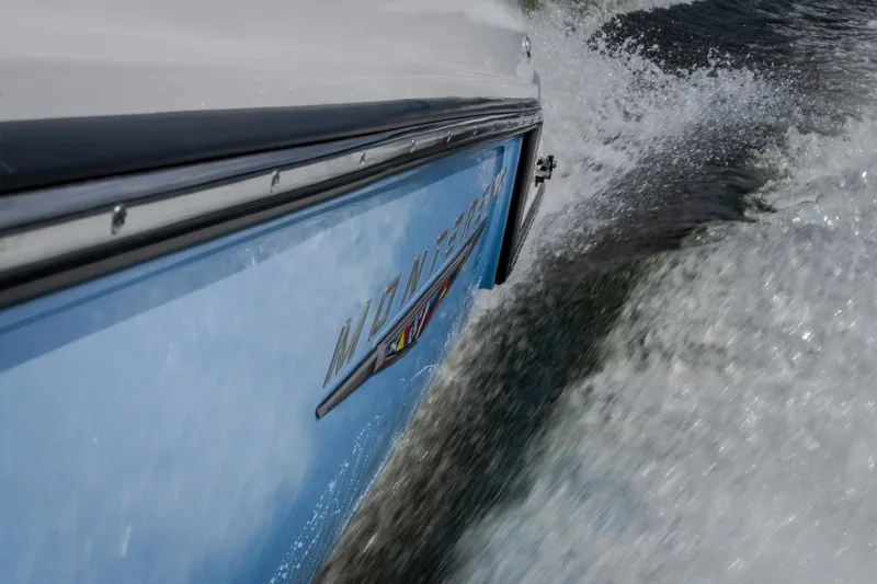Slide: The Image of 2026 Monterey Elite 30 OB boat cruising through water, side view. - 52
