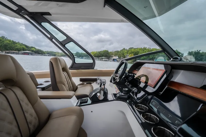 Slide: The Image of Luxurious interior of 2026 Monterey Elite 30 OB boat with modern dashboard and plush seating. - 21