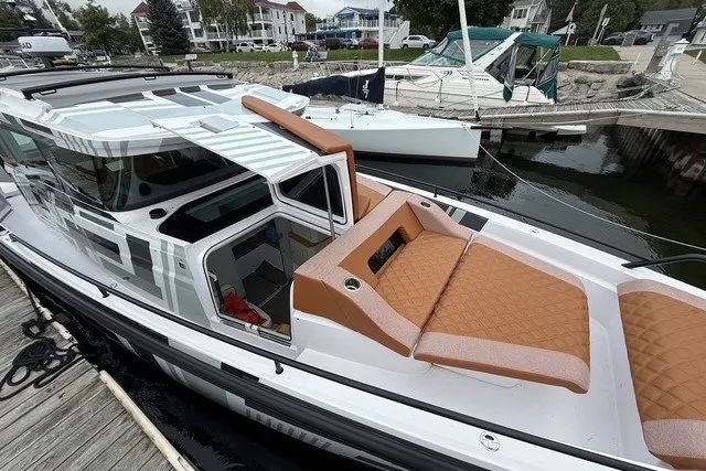 Slide: The Image of 2025 Axopar 37 XC Cross Cabin boat docked, featuring sleek design and comfortable seating. - 8