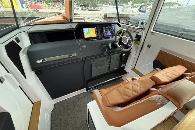 Slide: The Image of 2025 Axopar 37 XC Cross Cabin interior with modern dashboard and leather seating. - 16