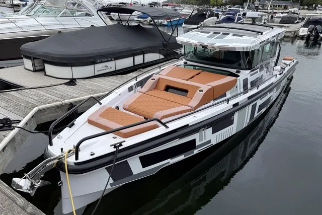 Slide: The Image of 2025 Axopar 37 XC Cross Cabin boat docked in marina, featuring sleek design and spacious deck. - 6