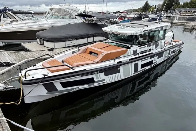 Slide: The Image of 2025 Axopar 37 XC Cross Cabin boat docked in a marina, featuring modern design. - 5