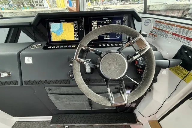 Slide: The Image of 2025 Axopar 37 XC Cross Cabin helm with advanced navigation displays and sleek steering wheel. - 17