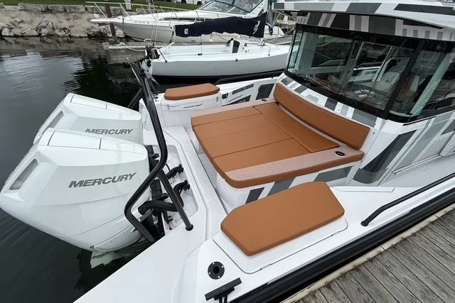 Slide: The Image of 2025 Axopar 37 XC Cross Cabin with Mercury engines, docked, featuring tan seating. - 11