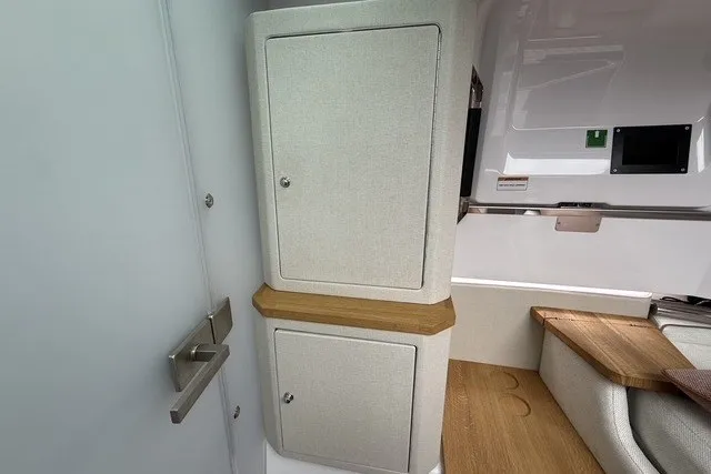 Slide: The Image of 2025 Axopar 37 XC Cross Cabin interior with modern cabinetry and wood accents. - 28