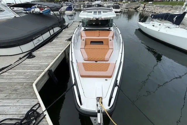 Slide: The Image of 2025 Axopar 37 XC Cross Cabin docked, featuring sleek design and spacious seating. - 9