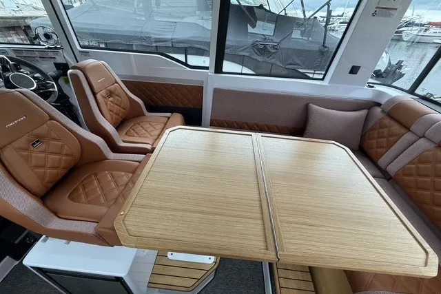 Slide: The Image of Luxurious interior of 2025 Axopar 37 XC Cross Cabin with leather seating and wooden table. - 23
