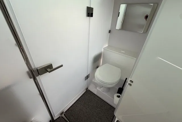 Slide: The Image of 2025 Axopar 37 XC Cross Cabin bathroom interior with modern fixtures and mirror. - 27