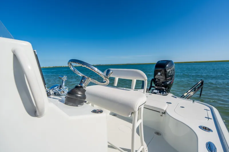 Slide: The Image of 2013 Yellowfin 24 Bay boat steering area with clear blue sky and water backdrop. - 8