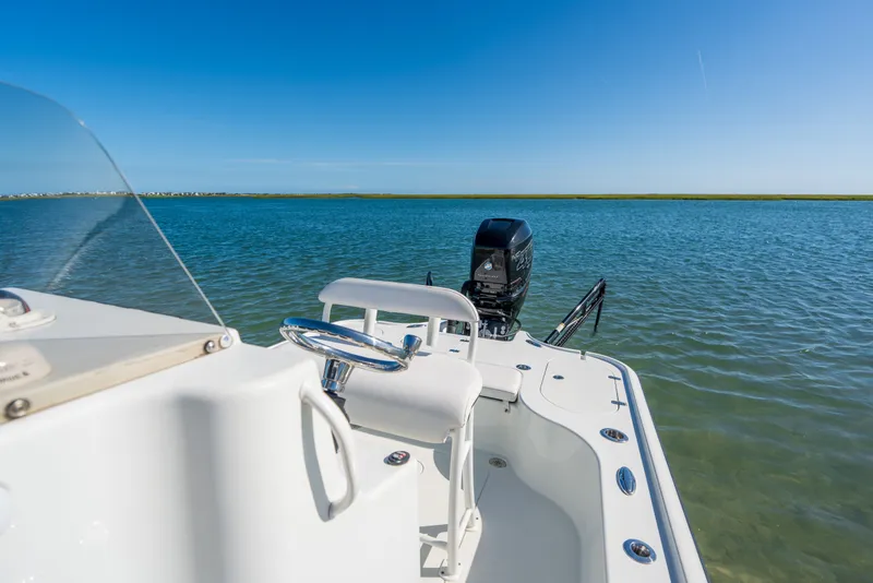 Slide: The Image of 2013 Yellowfin 24 Bay boat on calm water under clear blue sky. - 7