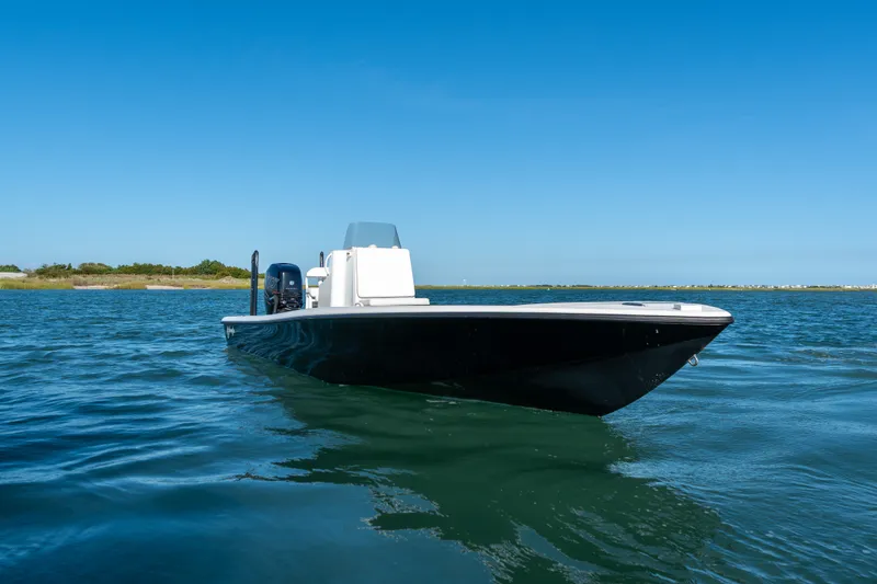 Slide: The Image of 2013 Yellowfin 24 Bay boat on calm water under clear blue sky. - 2