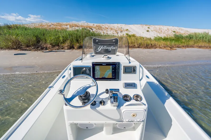 Slide: The Image of 2013 Yellowfin 24 Bay boat with navigation system, docked on a sandy beach. - 13