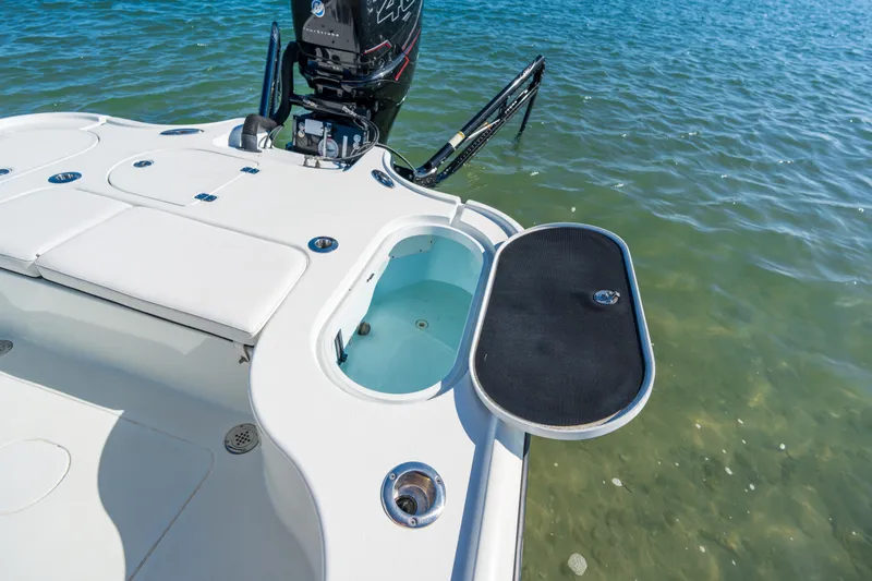 Slide: The Image of 2013 Yellowfin 24 Bay boat with open livewell and motor on calm water. - 11