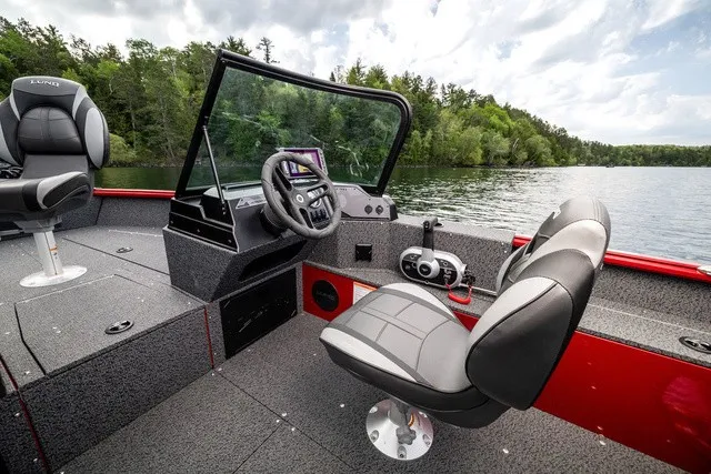 Slide: The Image of The image shows the cockpit of a 2027 Lund 1700 Adventure Sport boat on a lake. - 12