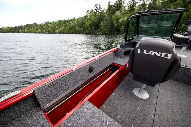 Slide: The Image of The image shows the interior of a 2027 Lund 1700 Adventure Sport boat on a calm lake. - 9