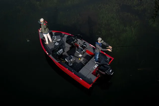 Slide: The Image of Two people fishing on a red Lund 1700 Adventure Sport boat on calm water. - 3