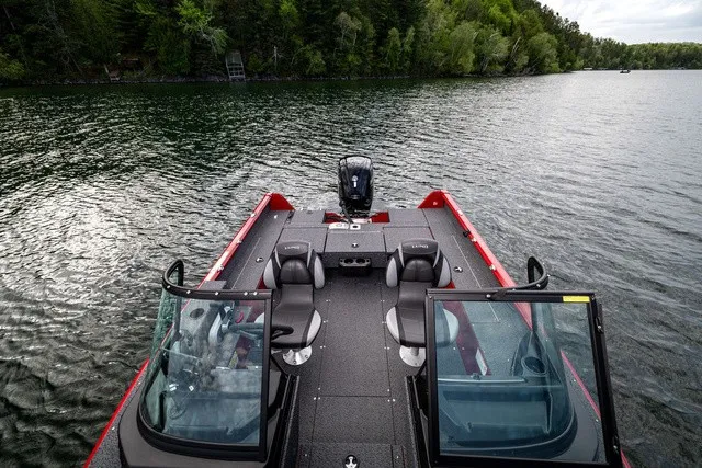 Slide: The Image of A Lund 1700 Adventure Sport boat on a calm lake with a wooded shoreline in the background. - 7