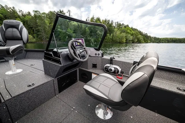 Slide: The Image of The image shows a modern boat with two cushioned seats and a helm on a calm lake. - 12