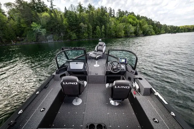 Slide: The Image of The image shows a Lund 1700 Adventure Sport boat on a calm lake, surrounded by trees. - 6