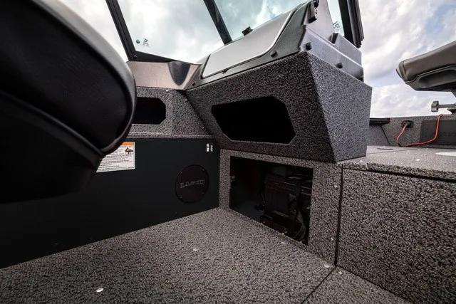 Slide: The Image of Interior of a Lund 1700 Adventure Sport boat with gray carpeting and storage compartments. - 11