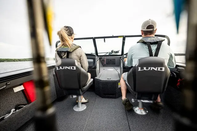 Slide: The Image of Two people seated in a Lund 1875 Fisherman boat, navigating on the water. - 10
