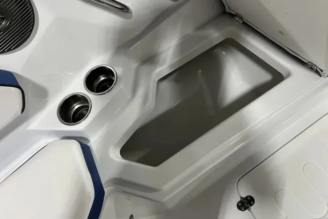 Slide: The Image of The image shows part of the interior of a 2025 Scarab 255 LX boat with cup holders and storage. - 30