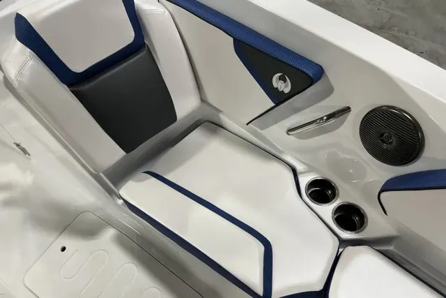 Slide: The Image of The 2025 Scarab 255 LX interior features white and blue upholstery with cup holders and speakers. - 27