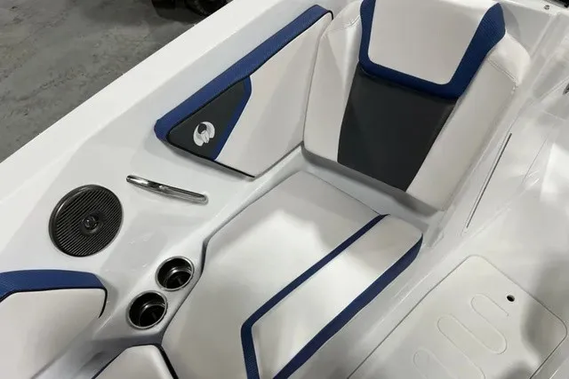 Slide: The Image of The interior of the 2025 Scarab 255 LX features white and blue upholstery with cup holders. - 29