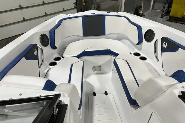 Slide: The Image of The image shows the cockpit of a 2025 Scarab 255 LX boat with white and blue upholstery. - 25