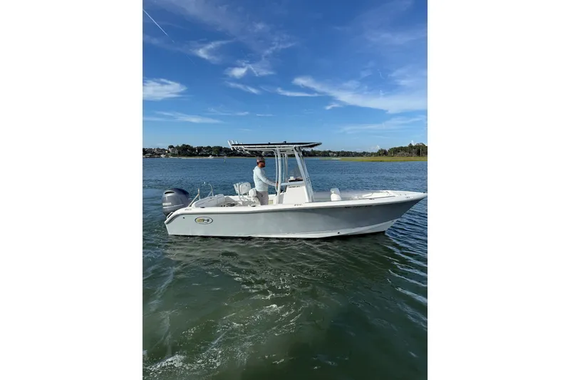 The Image of 2018 Sea Hunt Ultra 211 boat on calm water under clear blue sky. - 1