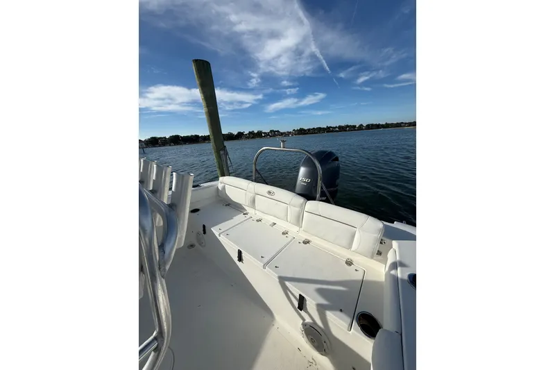 Slide: The Image of 2018 Sea Hunt Ultra 211 boat on calm water under a clear blue sky. - 18