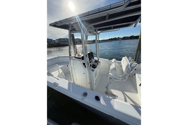Slide: The Image of 2018 Sea Hunt Ultra 211 boat with T-top, docked on a sunny day. - 20