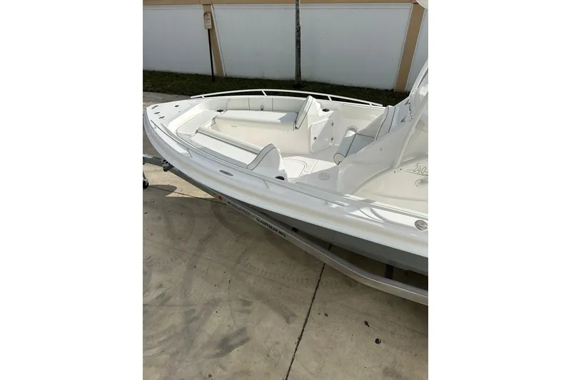 Slide: The Image of 2025 Glassream 240 CCX boat, white interior, parked on concrete surface. - 7