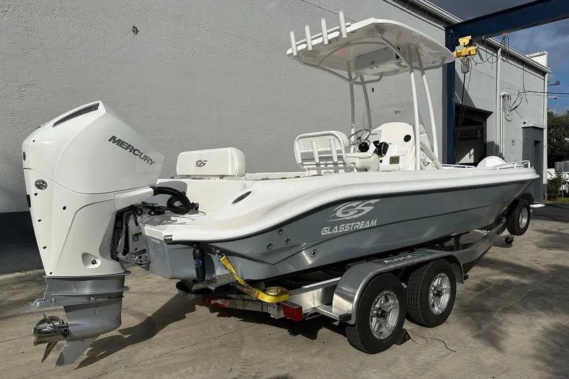 Slide: The Image of 2025 Glassream 240 CCX boat with Mercury engine on a trailer, parked outdoors. - 9