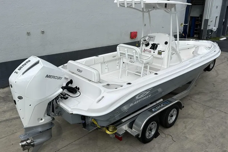 Slide: The Image of 2025 Glassream 240 CCX boat with Mercury engine on a trailer, parked outdoors. - 1