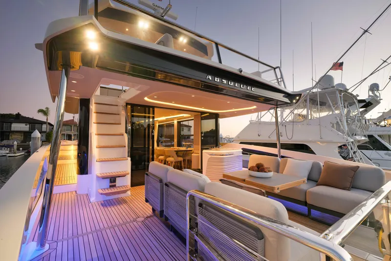 Slide: The Image of Luxurious 2027 Absolute Navetta 62 yacht with elegant deck seating at sunset. - 26