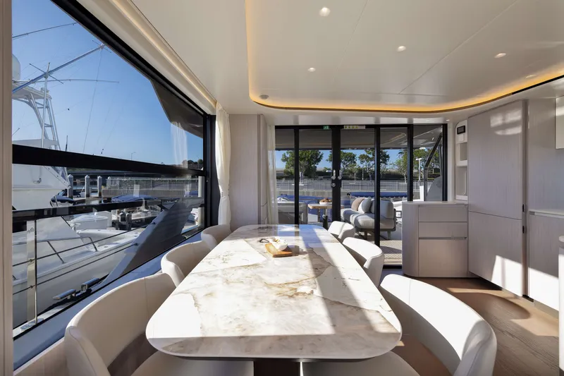 Slide: The Image of Luxurious interior of 2027 Absolute Navetta 62 yacht with elegant dining area and marina view. - 52