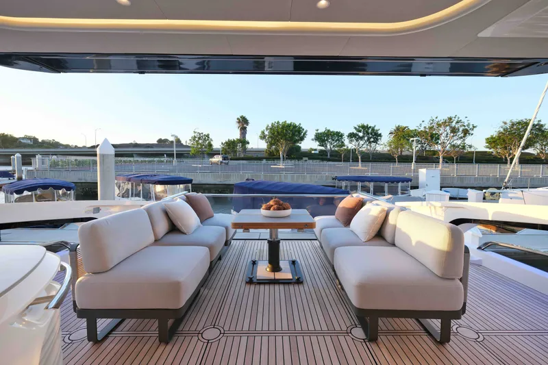 Slide: The Image of Luxurious 2027 Absolute Navetta 62 yacht deck with elegant seating and scenic marina view. - 25