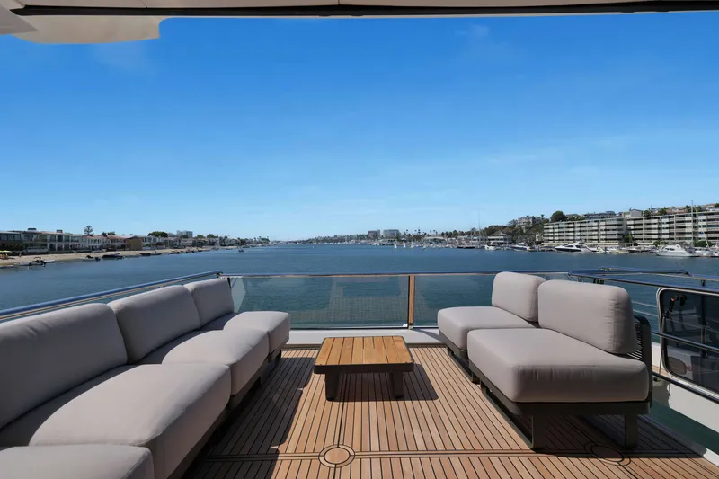 Slide: The Image of Luxurious Absolute Navetta 62 yacht deck with elegant seating, overlooking serene waterfront views. - 10
