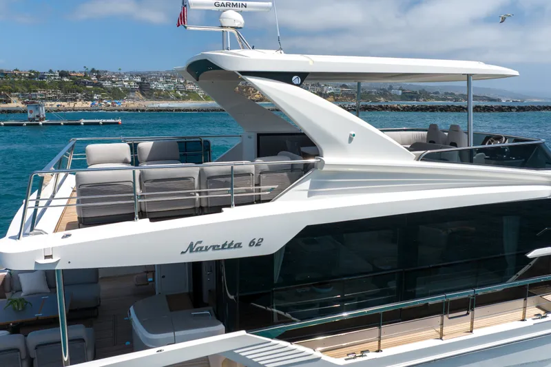 Slide: The Image of Luxury yacht Absolute Navetta 62, 2027 model, docked in scenic coastal waters. - 4